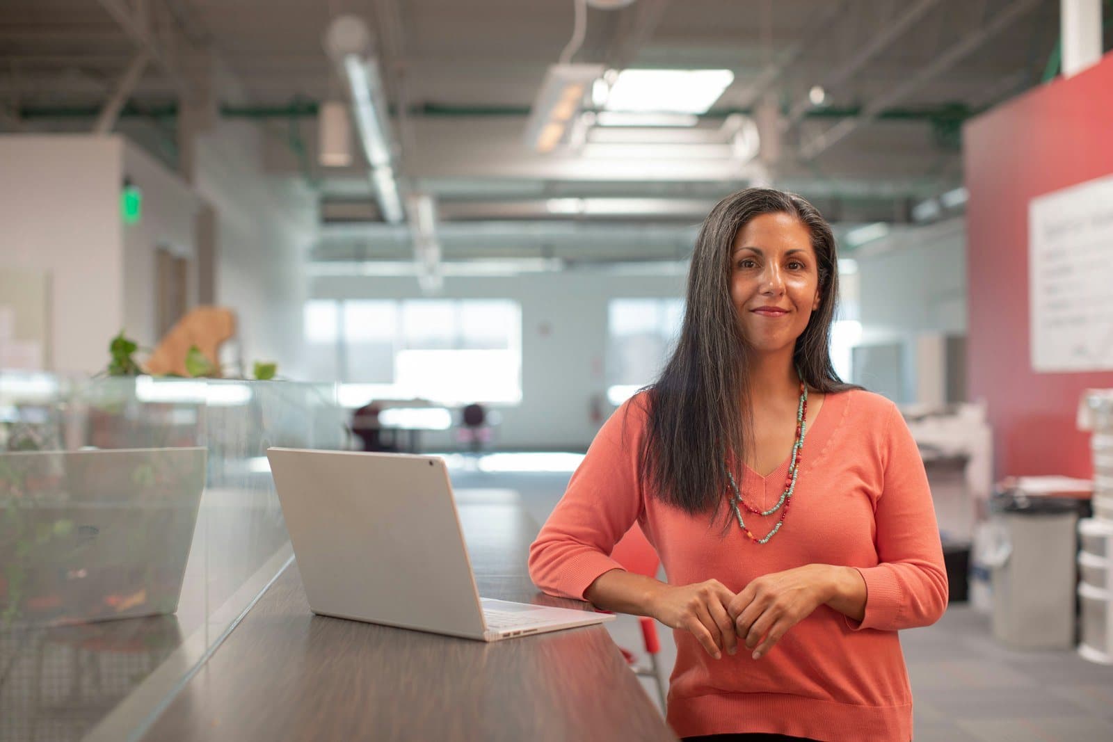 Anne Calder, the client's CFO, standing at a desk in an open office
