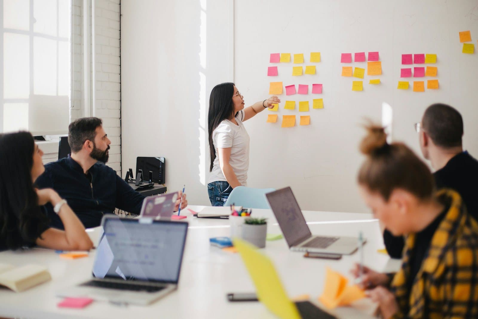 An underwriting team maps its review process on sticky notes on a whiteboard